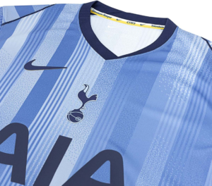 Close-up of a light-blue Tottenham Hotspur football jersey with a Nike swoosh and club crest on a striped patterned fabric