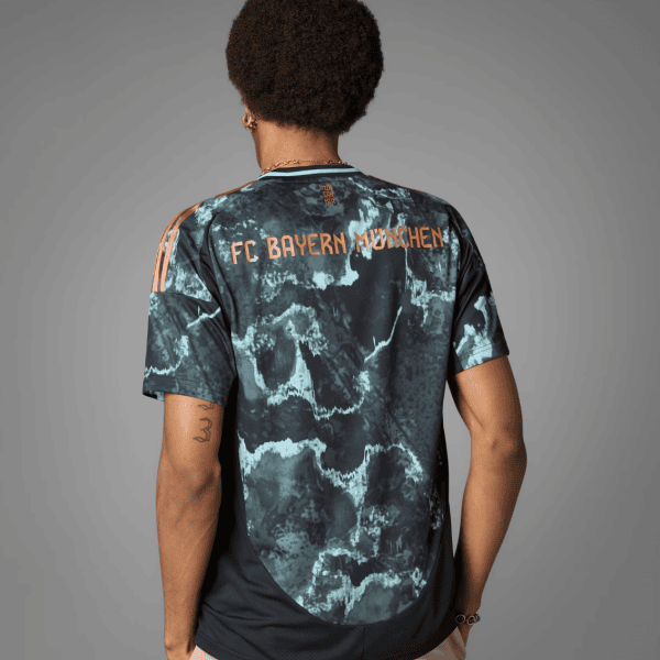 Back view of a person wearing a blue marble-patterned FC Bayern München jersey with orange lettering on the back.
