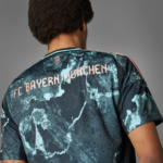 Back view of a person wearing a blue-green tie-dye FC Bayern München jersey with 'MIA SAN MIA' small text near the neckline.
