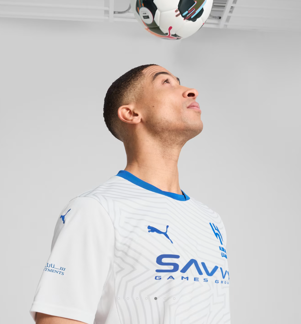 Screenshot_2024-09-04_203309 | UAE SPORT STORE Adult male in a white striped sports jersey looks up at a soccer ball hovering near the ceiling.