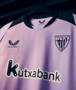 Pink soccer jersey on a hanger featuring the Athletic Club Bilbao crest, Castore branding, and Kutxabank sponsor logo across the chest.