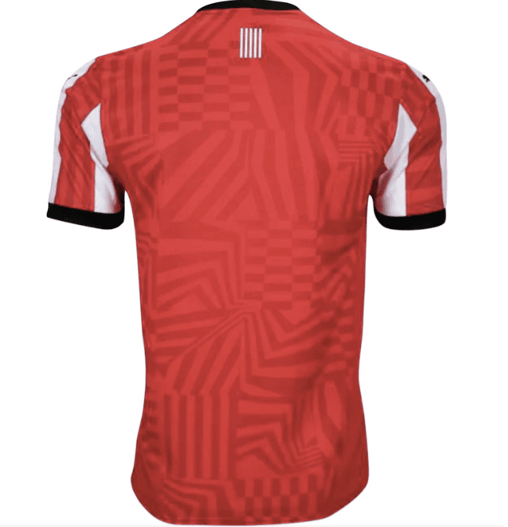 Screenshot_2024-09-26_214823 | UAE SPORT STORE Red geometric-patterned short-sleeve soccer jersey viewed from the back, with a black collar and black cuffs on the sleeves.