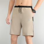 Beige knee-length men's swim shorts with black drawstring waistband, dark side stripe, and a small logo on the left leg.