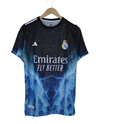 Blue Real Madrid football jersey on a hanger, featuring the Emirates Fly Better sponsor and club crest against a starry pattern.