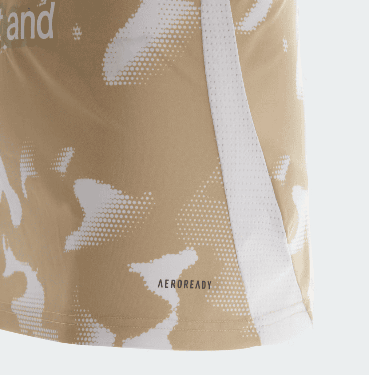 Close-up of a beige bag with white dotted camouflage pattern and a white strap across it; small 'AEROREADY' label visible.