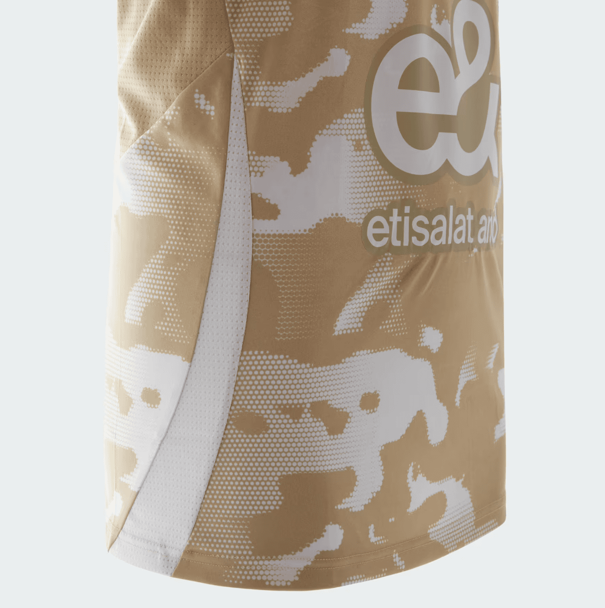Screenshot_2025-01-14_174508 | UAE SPORT STORE Close-up of a beige camouflage-patterned sports jersey with a white side panel and a large white logo text partially visible.