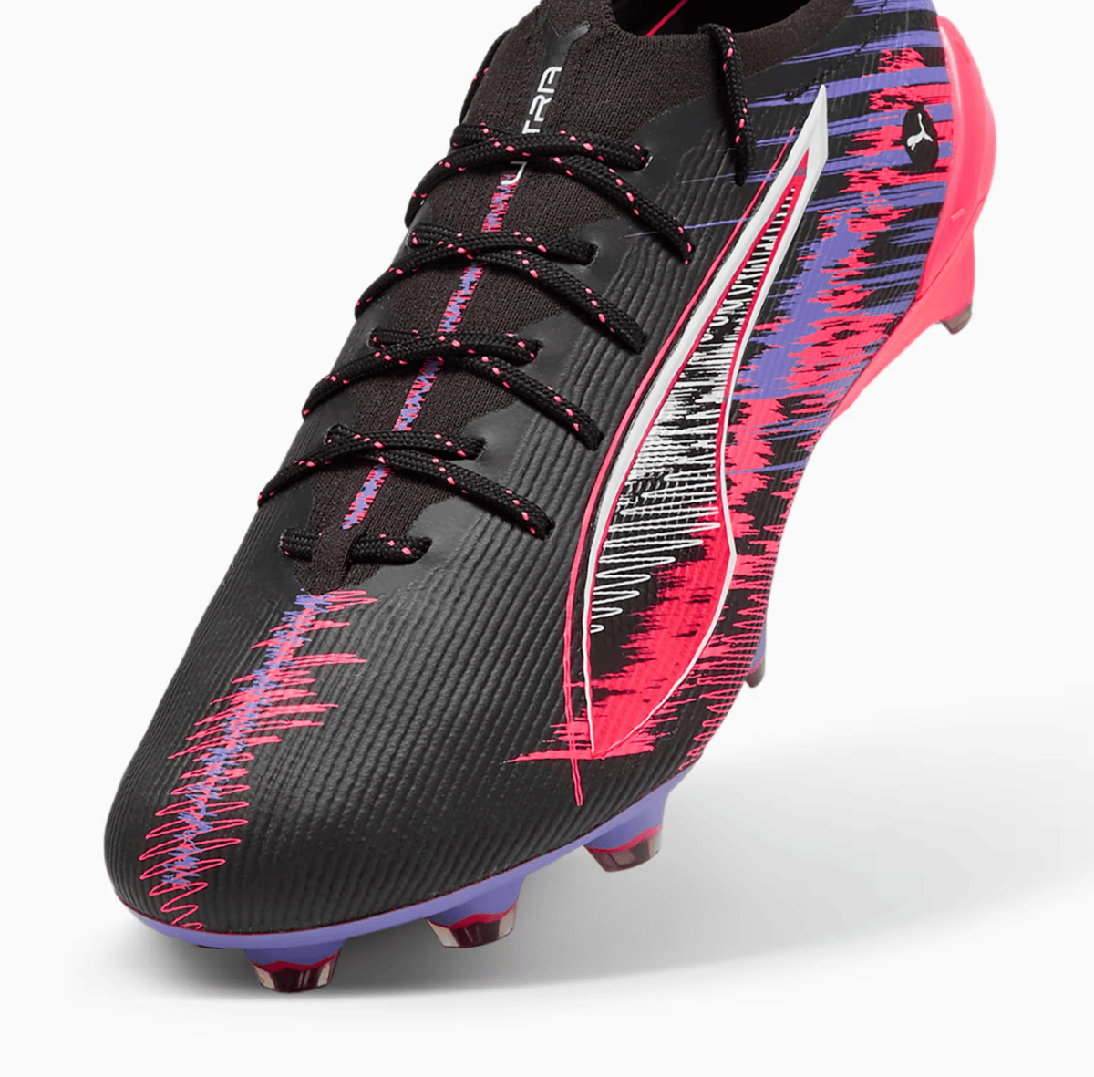 Black soccer cleat with pink-purple graphic pattern, laces, and studded sole for firm ground play
