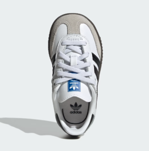 Top-down view of a white Adidas sneaker with gray toe cap and black stripes on the side.