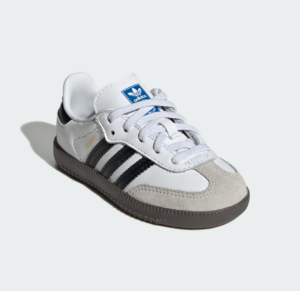 White Adidas Samba sneaker with black stripes and gray sole on a pale background, toe suede cap visible.