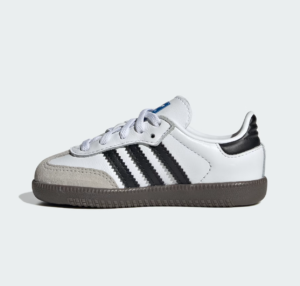 White low-top sneaker with black three stripes and gray suede toe cap on a brown sole (side view).