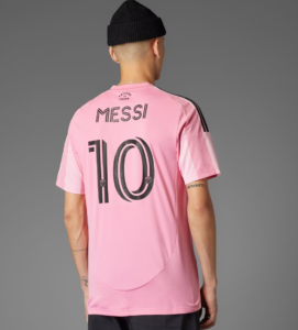 Back view of a pink Messi soccer jersey with the number 10 on the back and black stripe details on the shoulders. Small 'FREEDOM DREAM' text near the collar is visible.