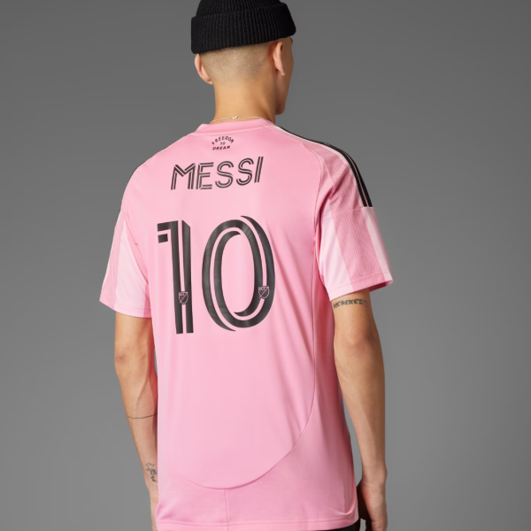 Back view of a pink Messi soccer jersey with the number 10 on the back and black stripe details on the shoulders. Small 'FREEDOM DREAM' text near the collar is visible.