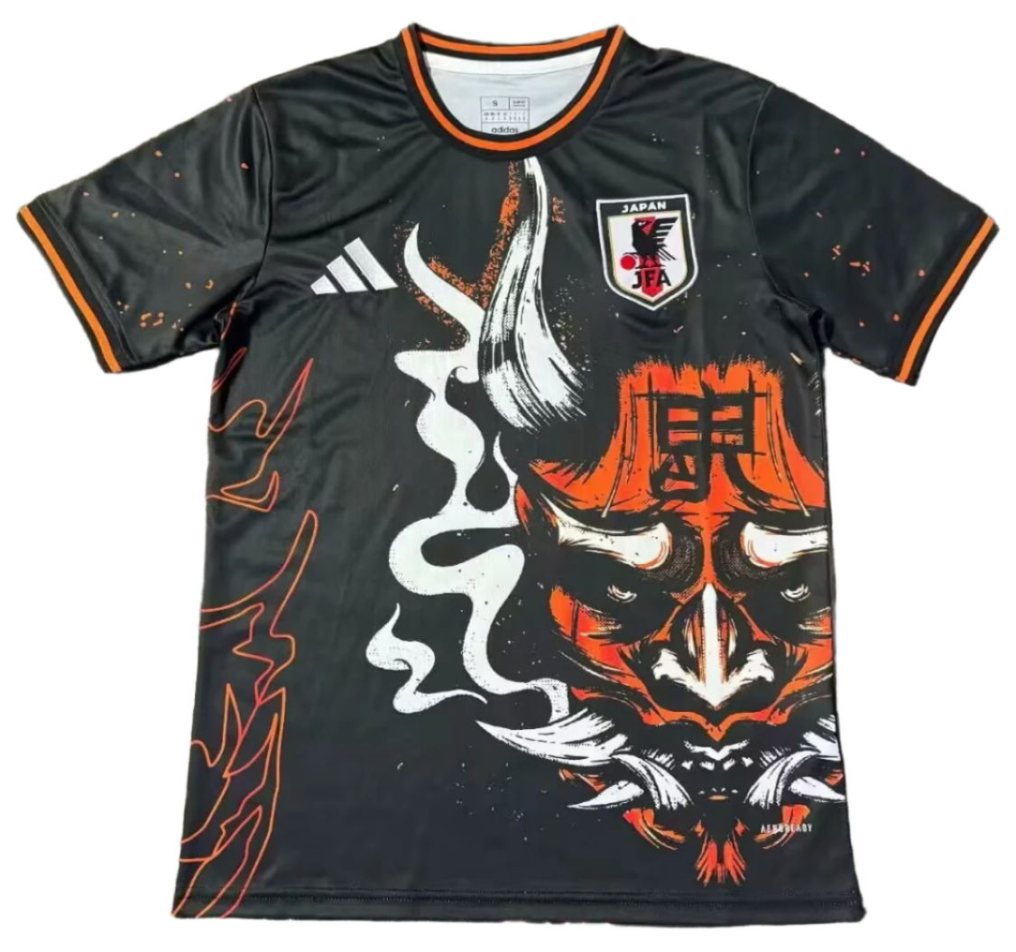 Screenshot_2025-03-15_014938 Black soccer jersey with orange trim and a large orange demon mask graphic, Japan IFA crest on the chest.