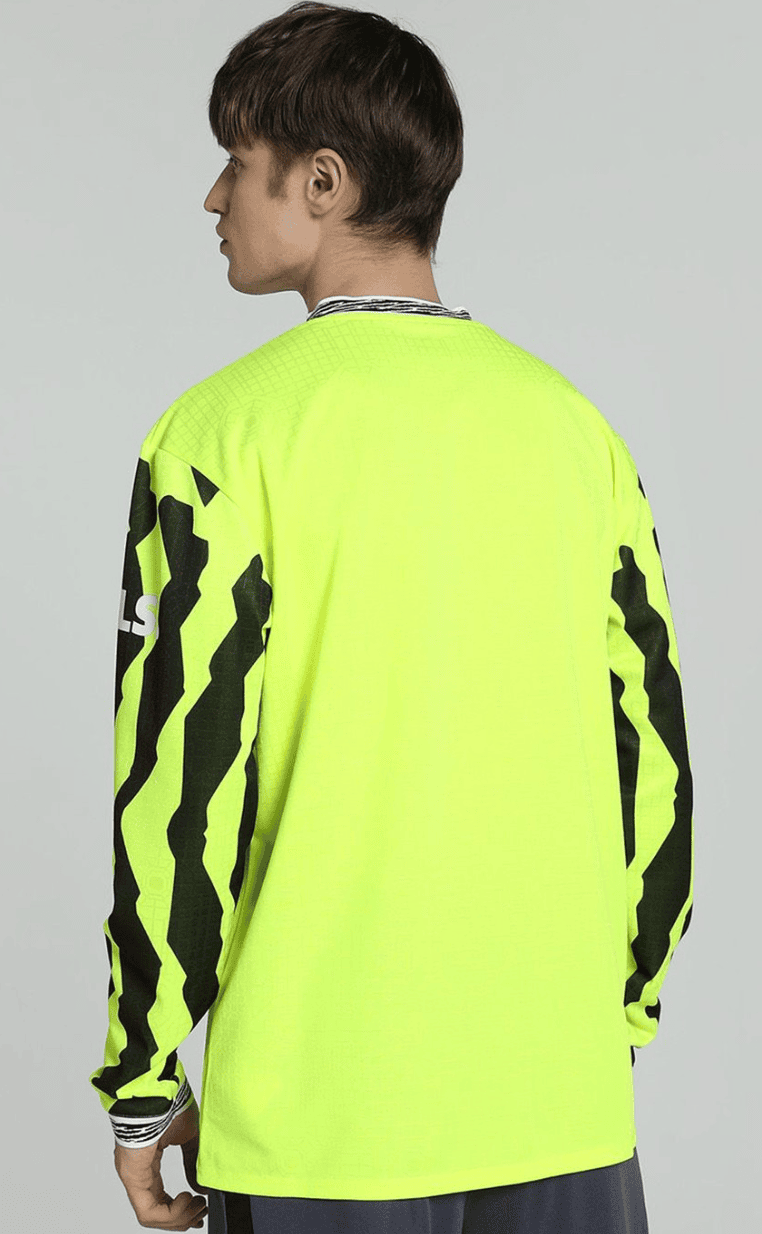 Screenshot_2025-04-13_053220 | UAE SPORT STORE Rear view of a neon yellow long-sleeve athletic jersey with black zigzag stripes along the sleeves and a dark collar edge.