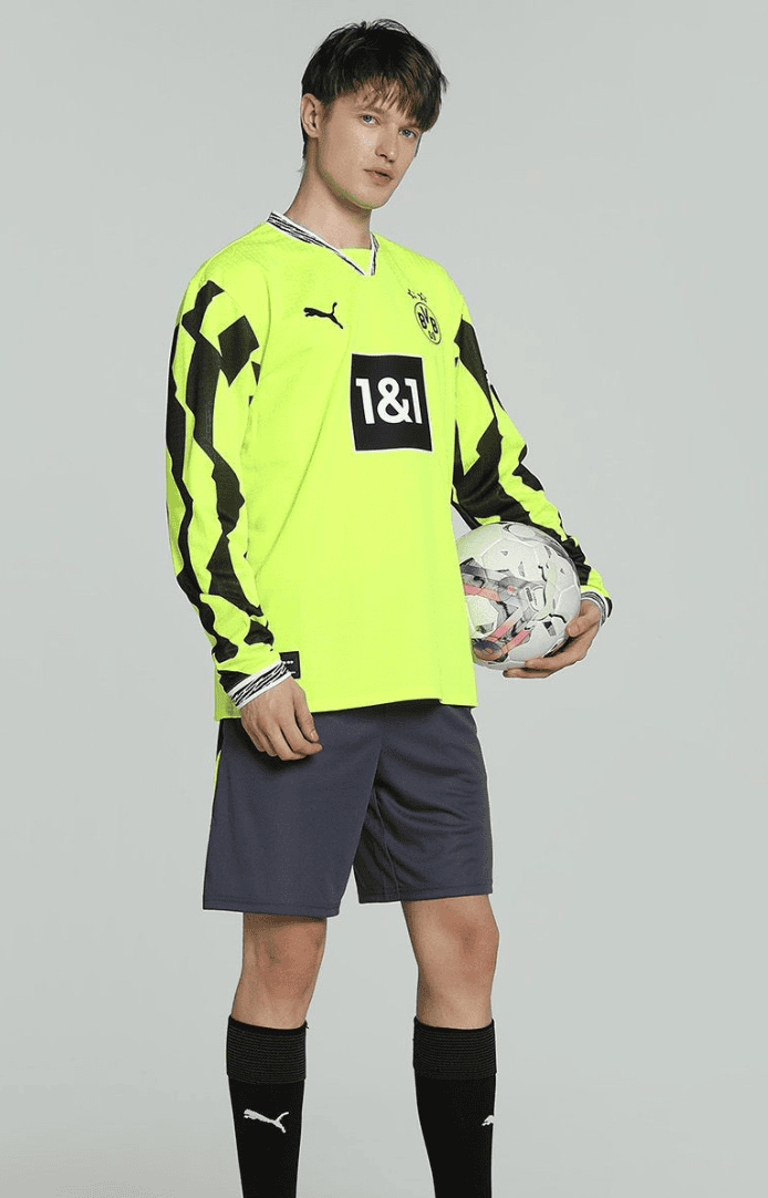 Screenshot_2025-04-13_053228 | UAE SPORT STORE Male soccer goalkeeper wearing a neon yellow jersey with a 1&1 sponsor, dark shorts, black socks, and holding a white soccer ball at his side.