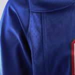 Close-up of royal blue athletic jersey fabric with a perforated ventilation panel and seam detail.