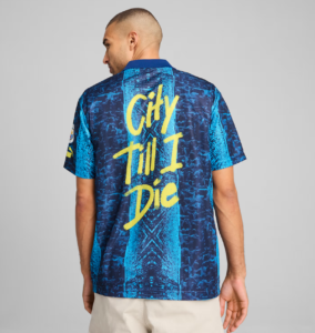 Man wearing a blue, patterned shirt viewed from the back, with bright yellow text reading 'City Till I Die' across the back.