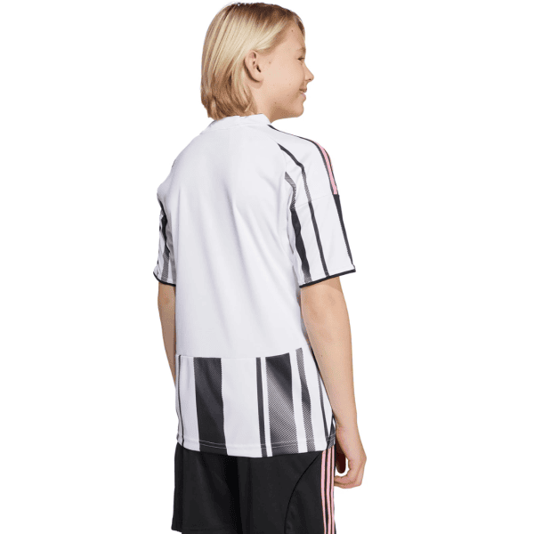 Back view of a child wearing a white sports jersey with bold black vertical stripes and pink trim, standing in profile
