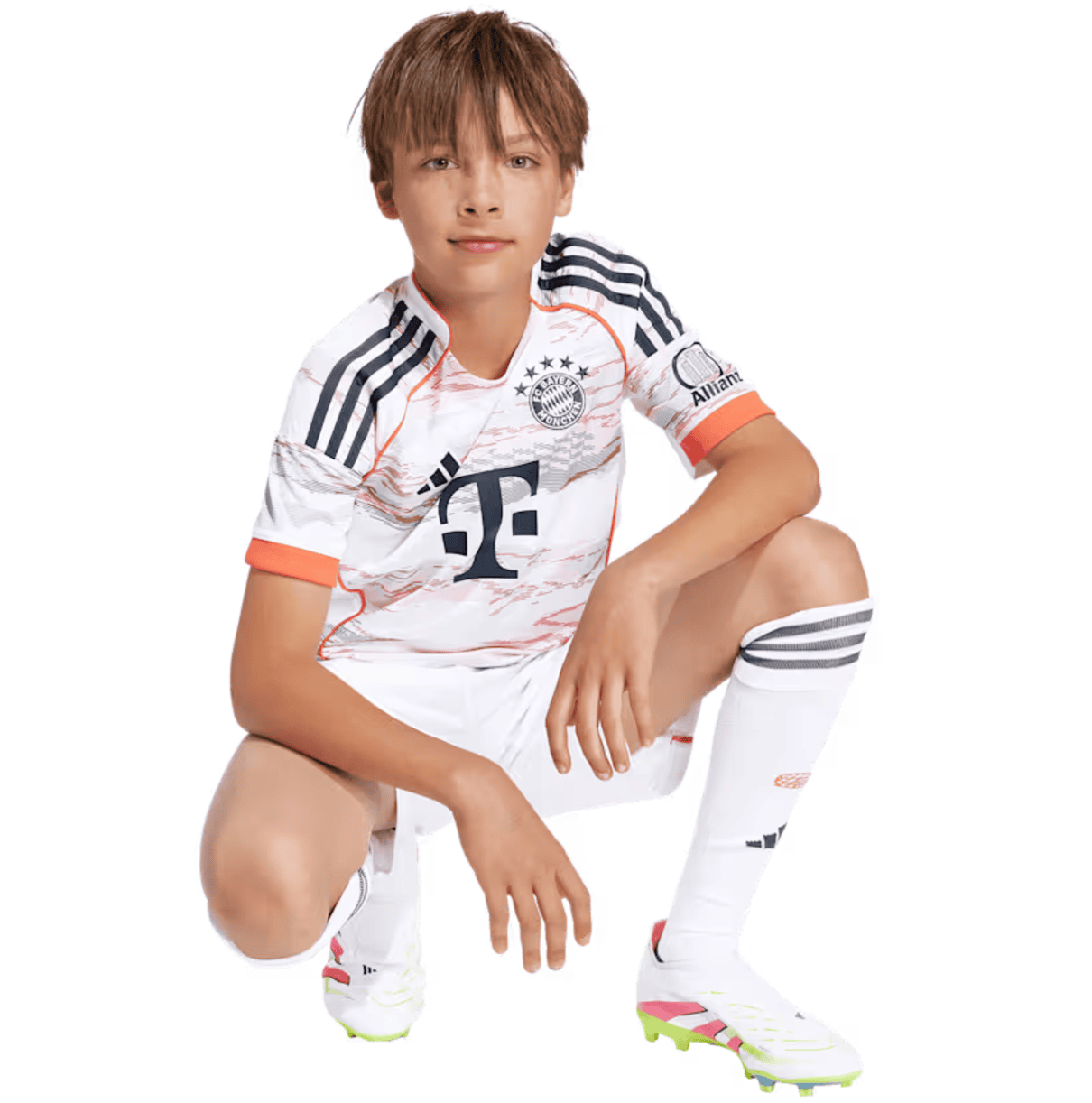 Screenshot_2025-06-19_040748 | UAE SPORT STORE Young boy wearing a white Bayern Munich soccer kit, kneeling with one knee up and looking at the camera.