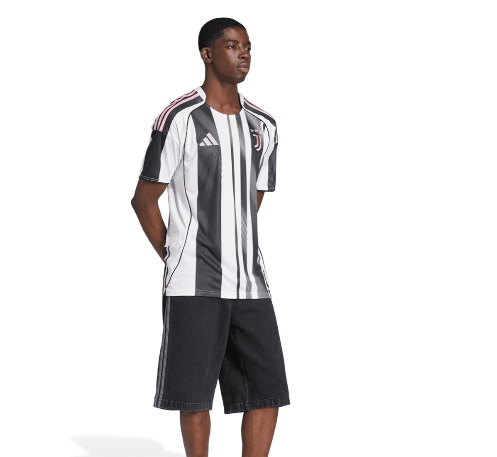Screenshot_2025-06-19_043451 | UAE SPORT STORE Male model wearing a Juventus-style black-and-white striped soccer jersey with pink accents and black shorts.