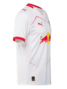 White football jersey with red trim and Red Bull sponsor logo on the front; features Puma logos on the chest and sleeve, and a subtle geometric pattern.
