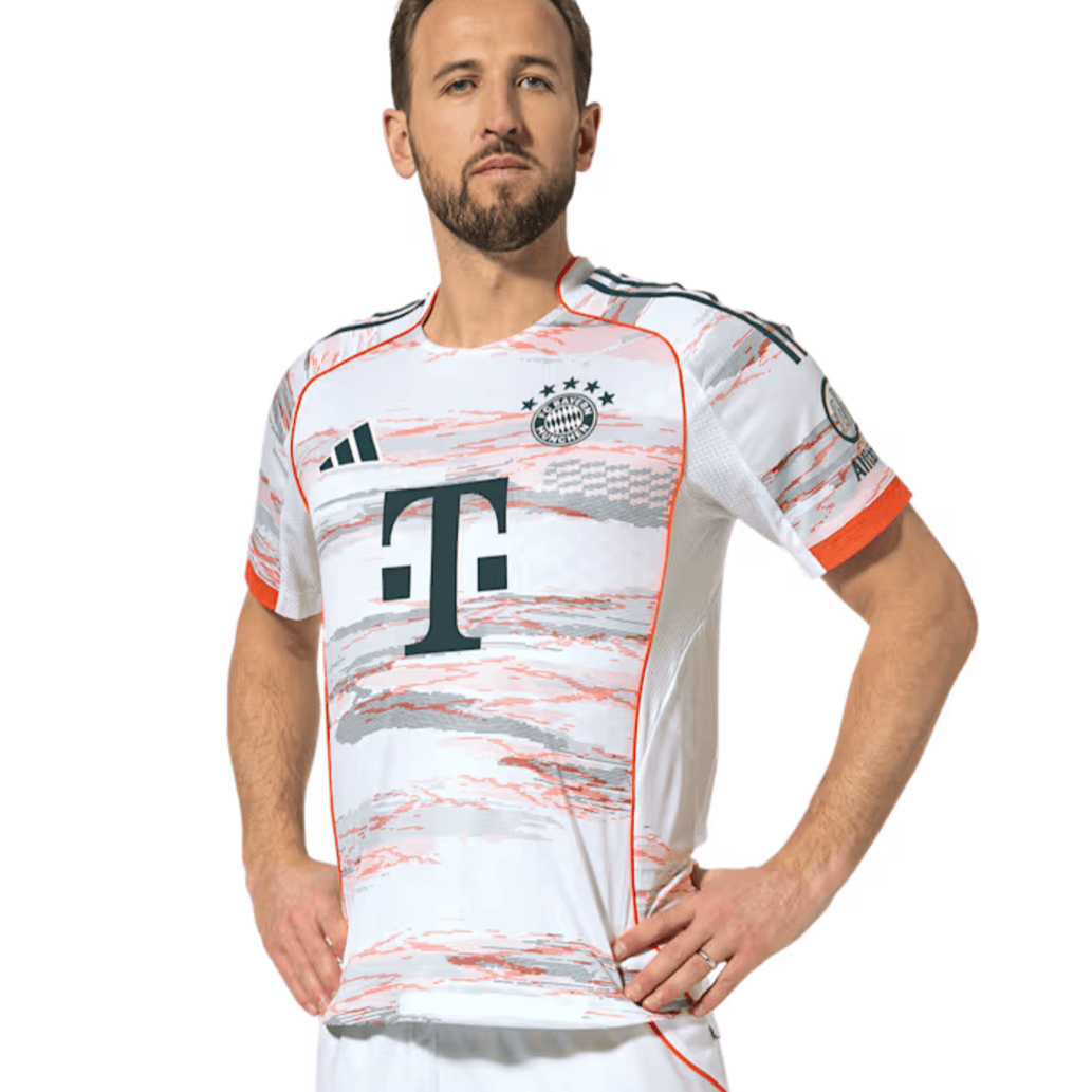Screenshot_2025-06-19_053447 | UAE SPORT STORE Man wearing a white Bayern Munich football jersey with orange trim, posing with hands on hips.