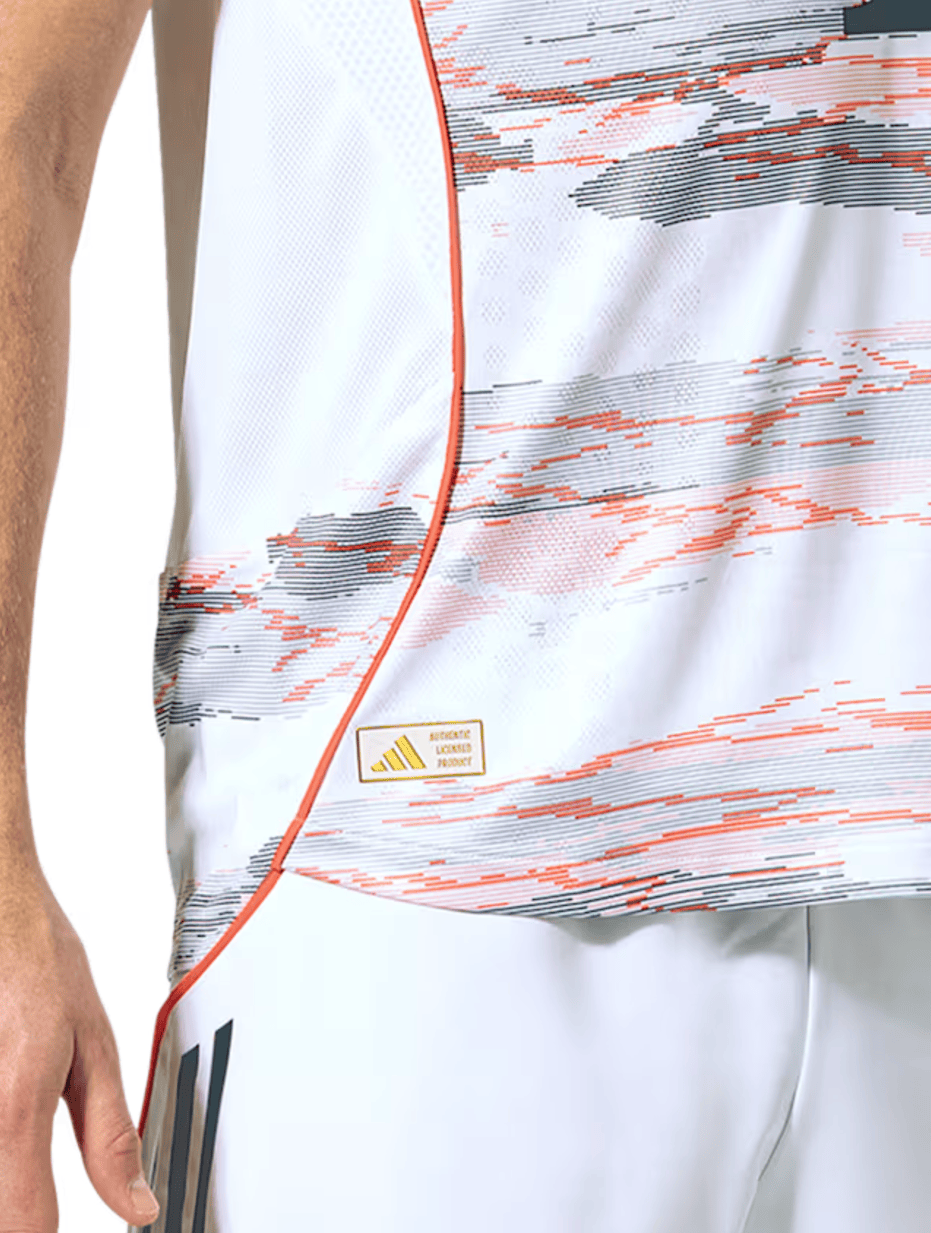 Screenshot_2025-06-19_053531 | UAE SPORT STORE Close-up of a white athletic jersey with orange and black graphic lines and a small 'Authentic Licensed Product' tag at the hem.