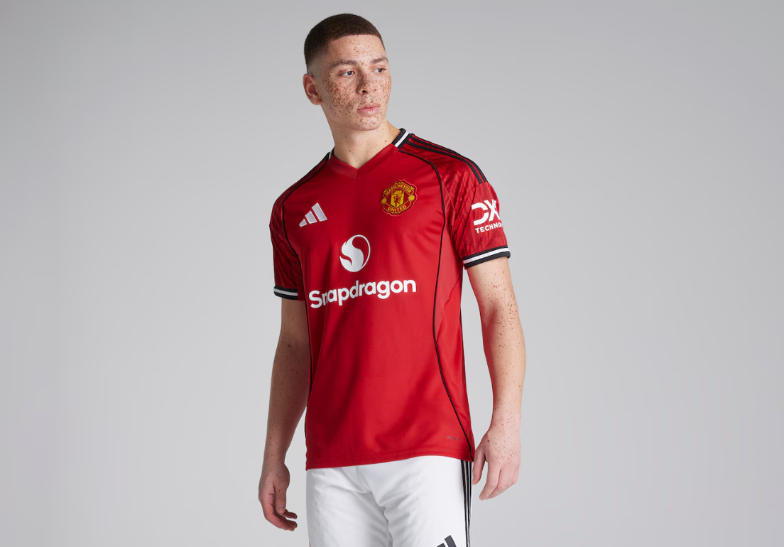 Screenshot_2025-06-23_193714 | UAE SPORT STORE Young man wearing a red Manchester United jersey with Snapdragon sponsor, standing against a gray background.