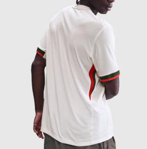 Screenshot_2025-06-23_194608 | UAE SPORT STORE Back view of a person wearing a white athletic polo with red and green stripes on the cuffs and side seam against a light gray background.