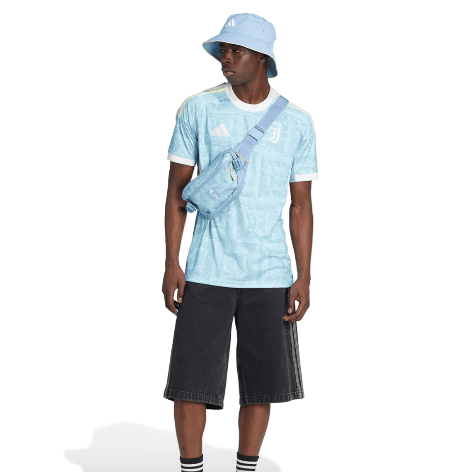 Screenshot_2025-06-23_195456 | UAE SPORT STORE Male model wearing a light-blue camo print T-shirt, matching bucket hat, and a blue crossbody bag across the chest