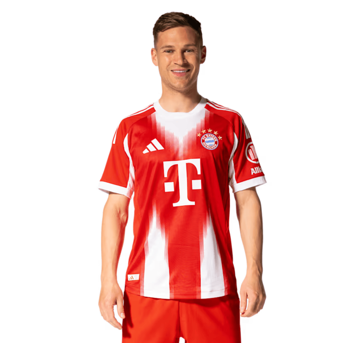 Male model wearing a red and white Bayern Munich home jersey, smiling at the camera, with T‑Mobile logo visible.