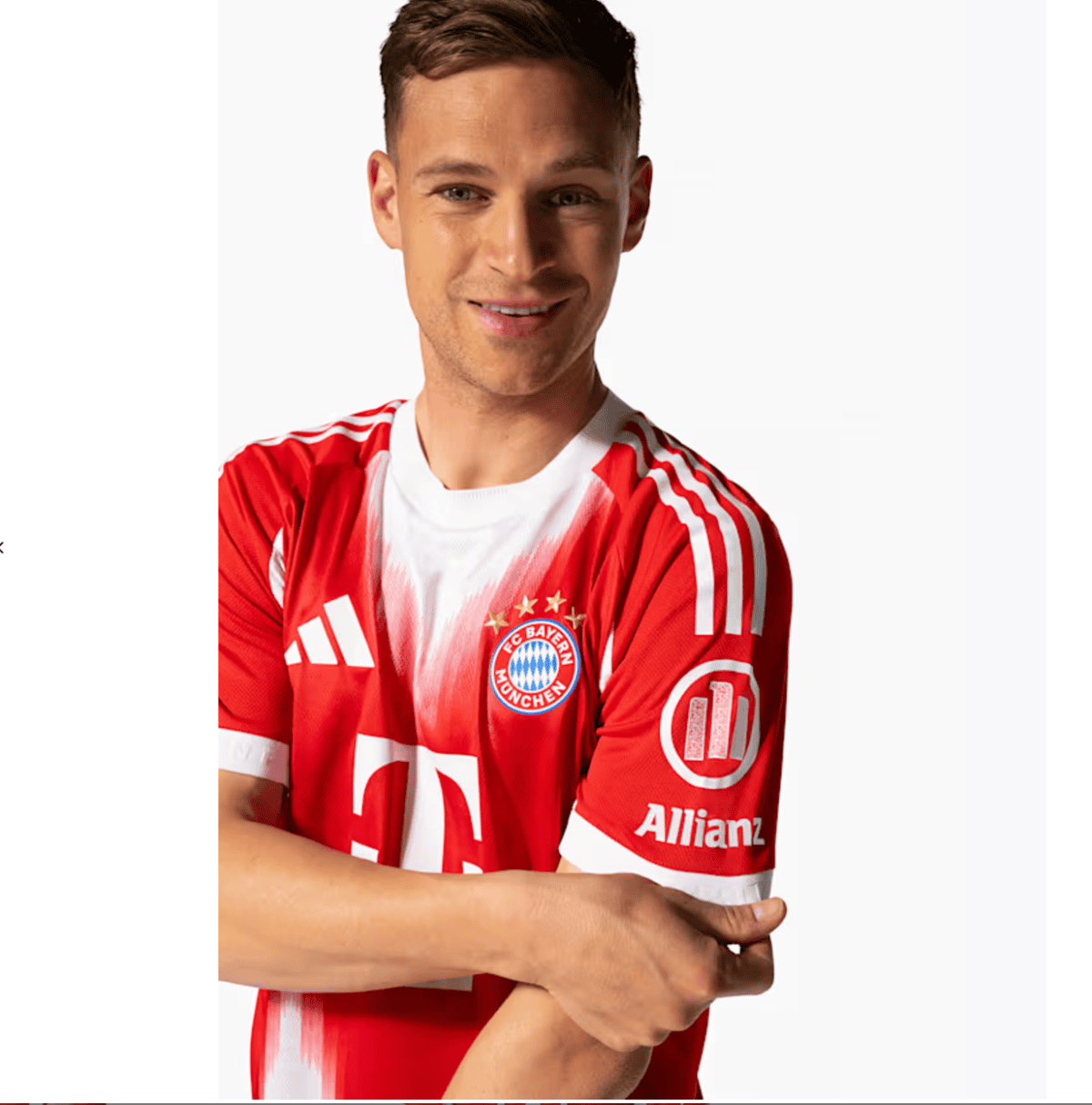 Smiling man in a red Bayern Munich football jersey with arms crossed in a portrait.