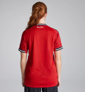 Person standing with back to camera in a red athletic jersey with black-and-white striped collar and cuffs.