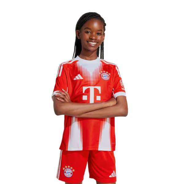 Young girl in a Bayern Munich red soccer jersey with arms crossed, smiling.