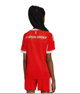 Back view of a person wearing a red FC Bayern Munich football jersey with white trim and matching shorts