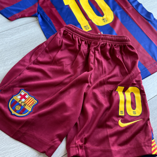 Barcelona FC maroon-and-blue jersey with the number 10 in yellow and name across the back, paired with matching maroon shorts featuring the club crest and a yellow Nike swoosh.