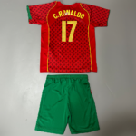 Red soccer jersey laid flat with 'C. Ronaldo 17' in yellow letters and a black starry pattern, paired with green shorts.