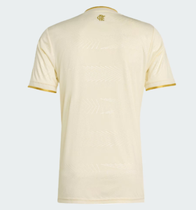 Back view of a cream-colored soccer jersey with gold neck trim and gold sleeve cuffs, subtle chevron texture across the fabric.