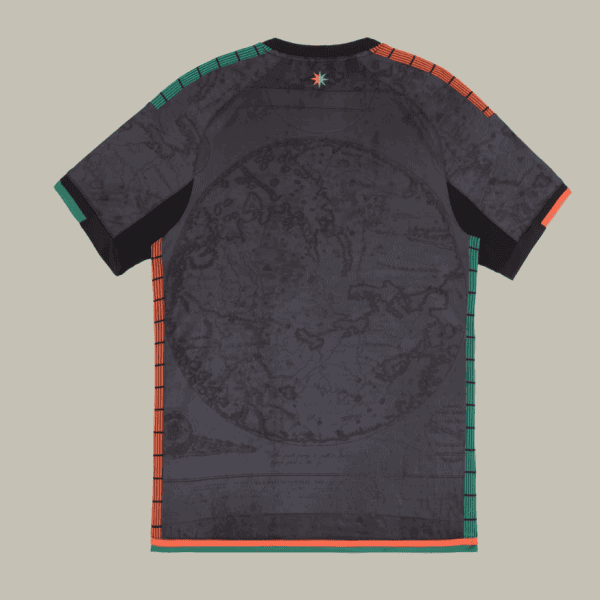 Dark gray graphic T-shirt with a map-like pattern, orange and green stitched seams along shoulders and sides, and a small star at the back neck.",
