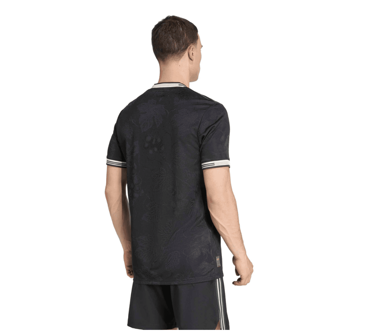 Back view of a man wearing a black floral-patterned T-shirt with white striped cuffs and collar.