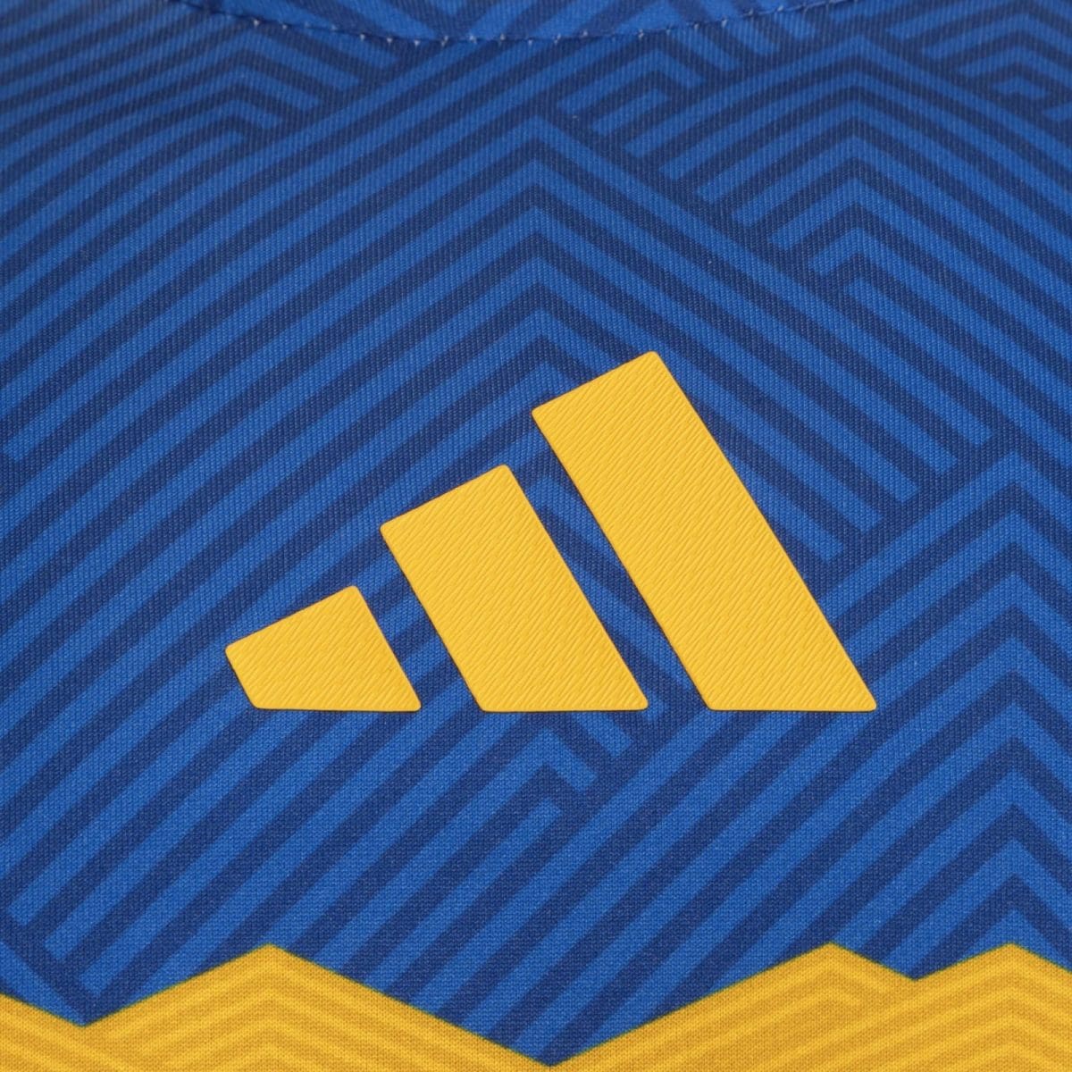 Close-up of blue chevron-patterned fabric with three yellow diagonal bars forming a stepped pattern.