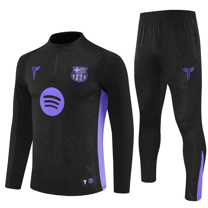 Survetement-Barca-Training-2025-2026-Noir Black FC Barcelona training top with purple accents and matching pants featuring side panels and logos.