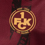 Gold circular anniversary logo on a burgundy jersey: reads 1900–2025 and 125 Jahre with a bold '1K FC' monogram.
