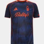 Front view of a navy blue football jersey with bright orange piping, Bally's sponsor text, Adidas logo, and team crest on the chest, plus a geometric pattern.