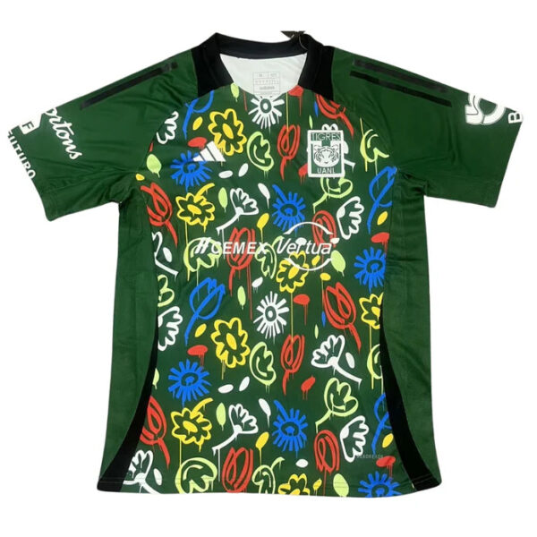 Green soccer jersey with a bold multicolored floral pattern on the front, black side panels, and a black collar; team crest on the left chest and sponsor text across the midsection, with green sleeves.