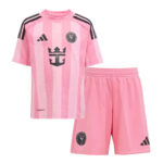 Pink striped soccer jersey with black crest and Adidas logo, paired with matching pink shorts featuring a team crest and stripes on the leg.