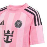 Close-up of a pink striped soccer jersey with an Adidas three-stripe shoulder design and a Miami FC crest on the chest.