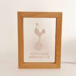 Wooden frame holding frosted paper with Tottenham Hotspur FC logo—a rooster standing on a football—with the club name beneath.