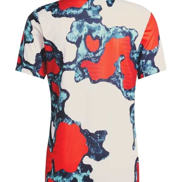 Back view of a short-sleeve shirt with red, blue, and cream abstract camouflage pattern.