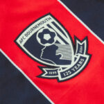 UKQke5DEhsgVkut | UAE SPORT STORE Close-up of an AFC Bournemouth crest patch on red and navy fabric, showing a stylized head with a football and 125 Years banner.